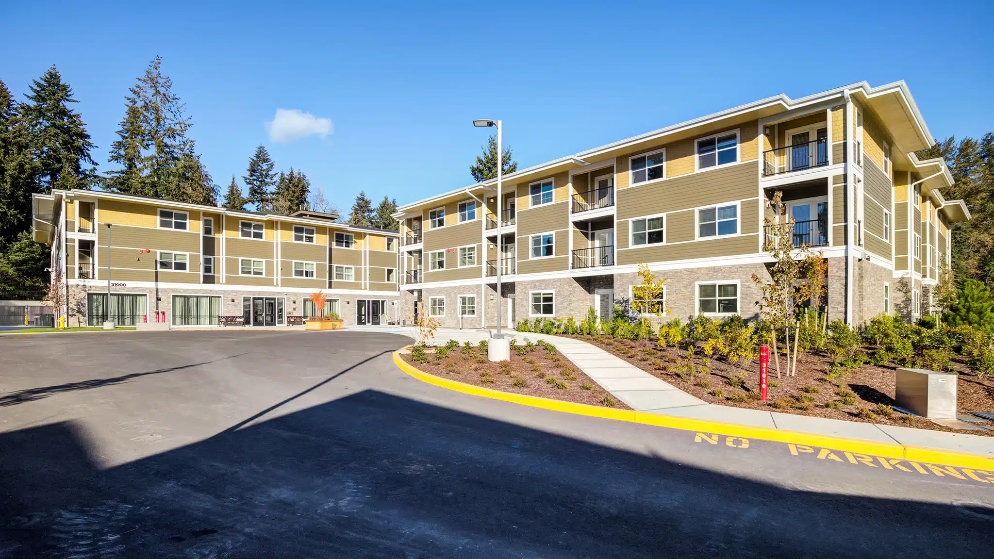 Driveway and exterior buildings of a senior living community on a sunny day.