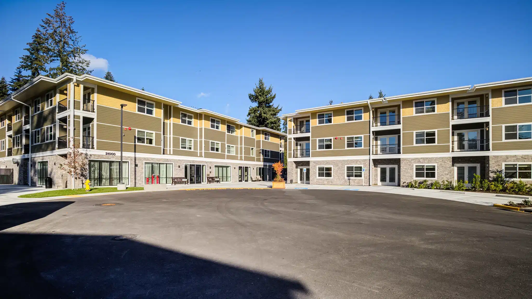 Wide view of senior living residential buildings with paved access and landscaping.